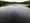 Still water, an oval pond surrounded by woods.